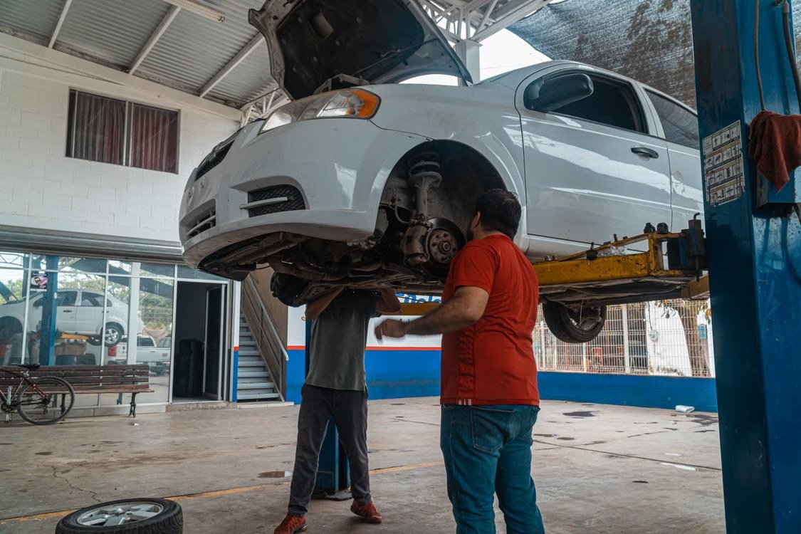 Δύο επιθεωρητές εξετάζουν όχημα σε ανυψωτικό